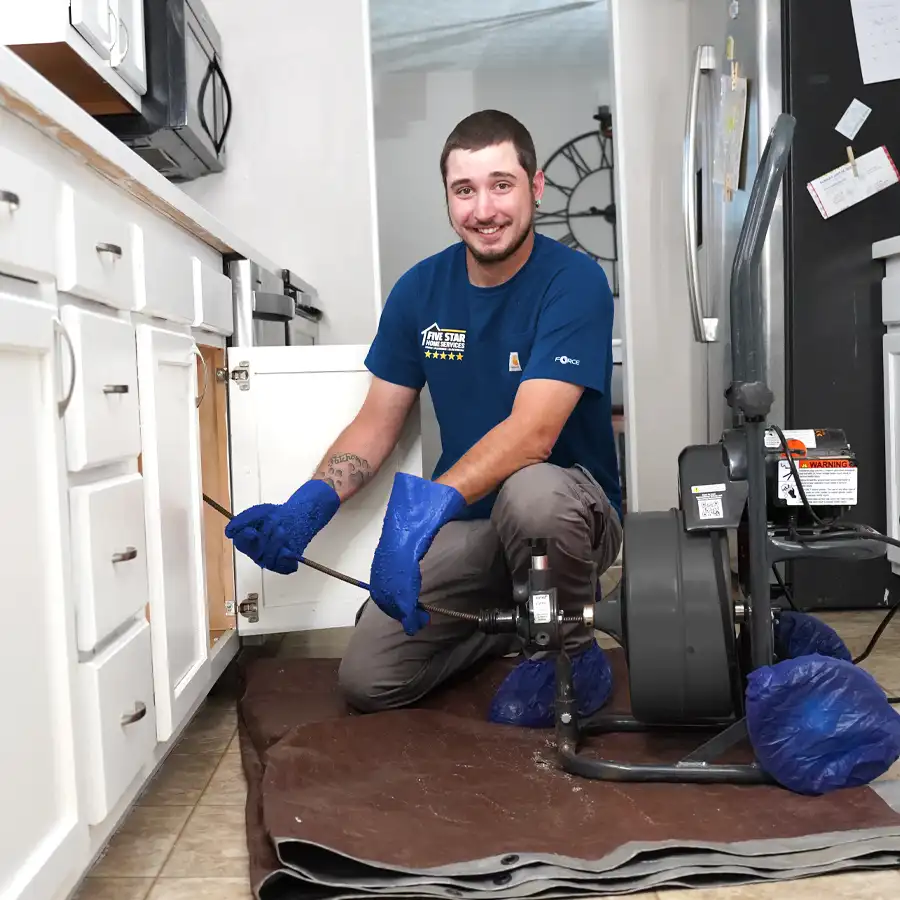 Plumber with video inspection equipment under a kitchen sink