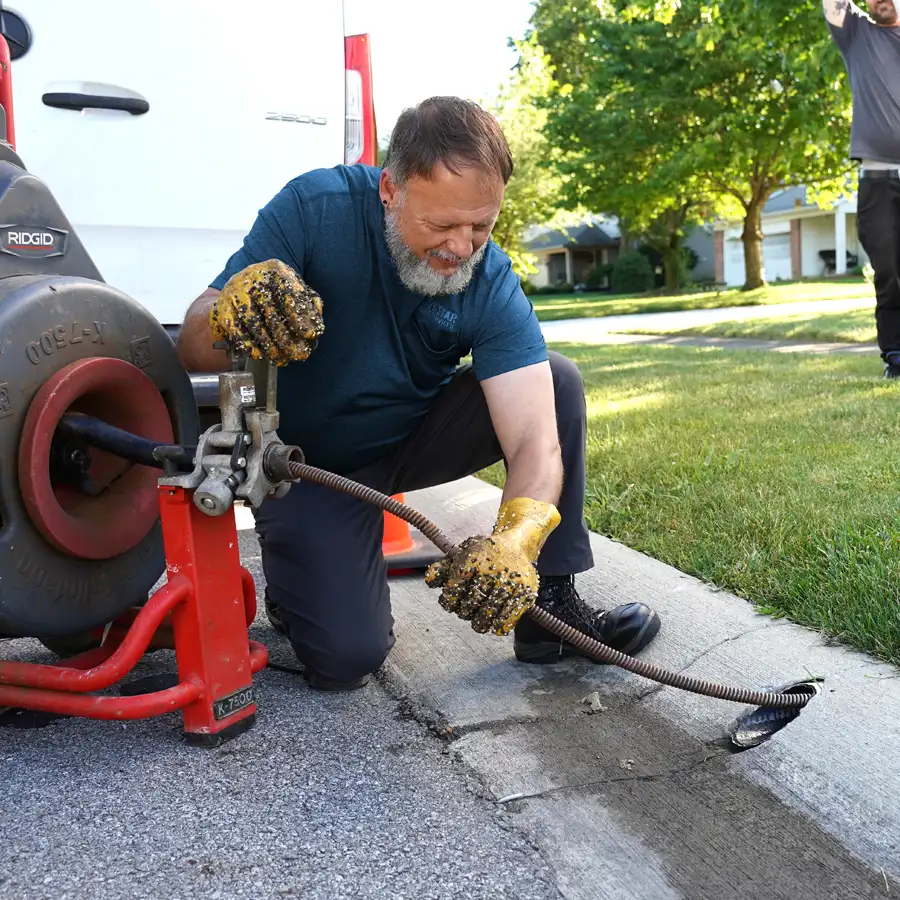 Plumber using a video camera inspection tool in a sewer line