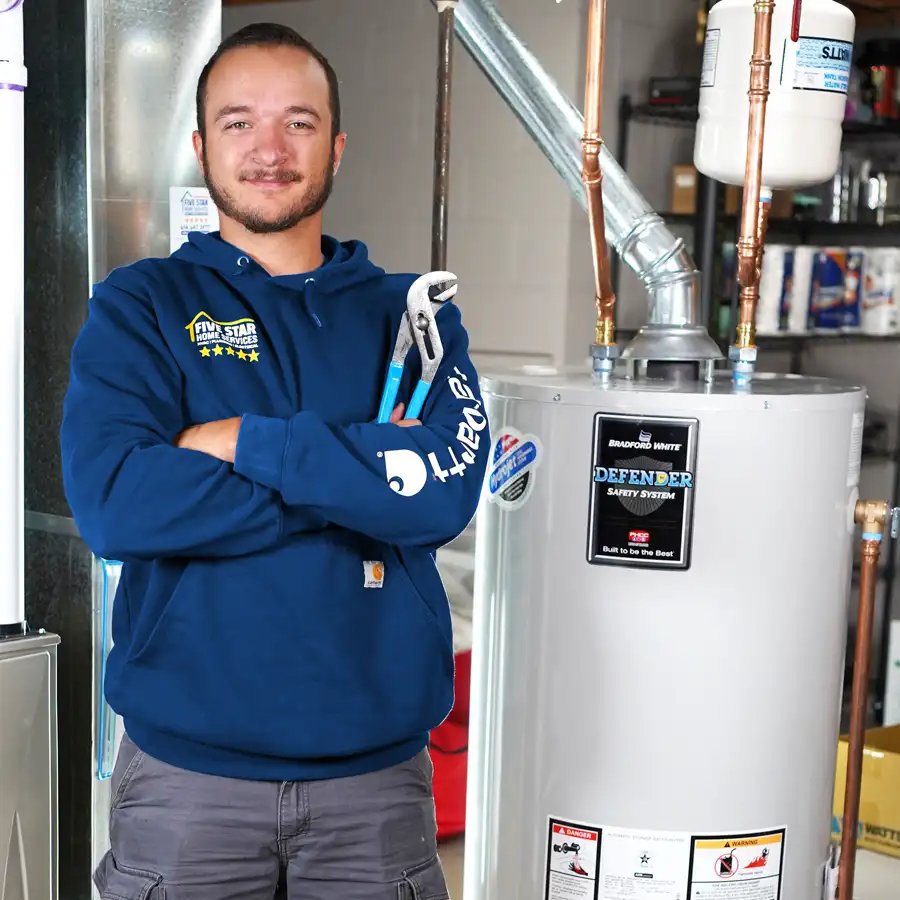 Plumber holding a wrench next to a water heater