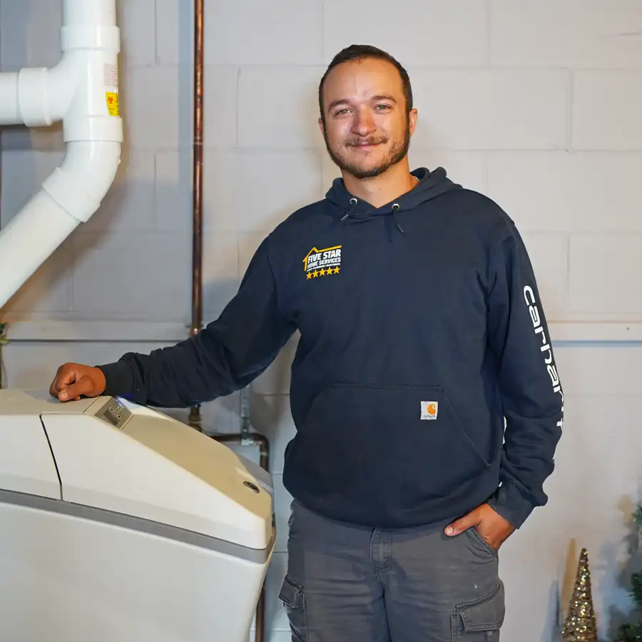 Plumber standing next to a water softener