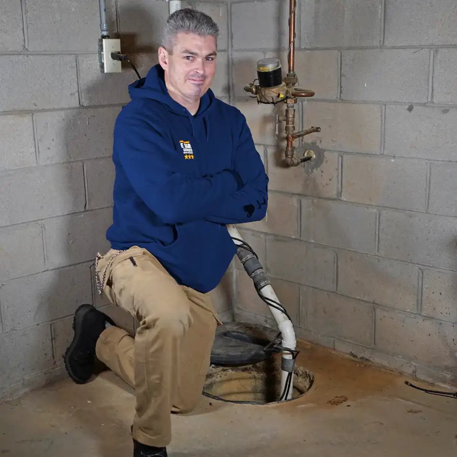 Plumber kneeling next to a sumb pump