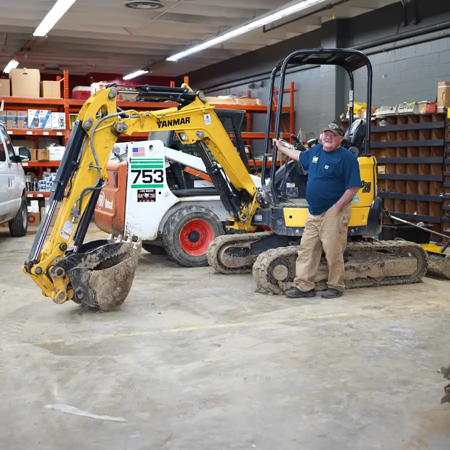 Plumber standing next to a excavator